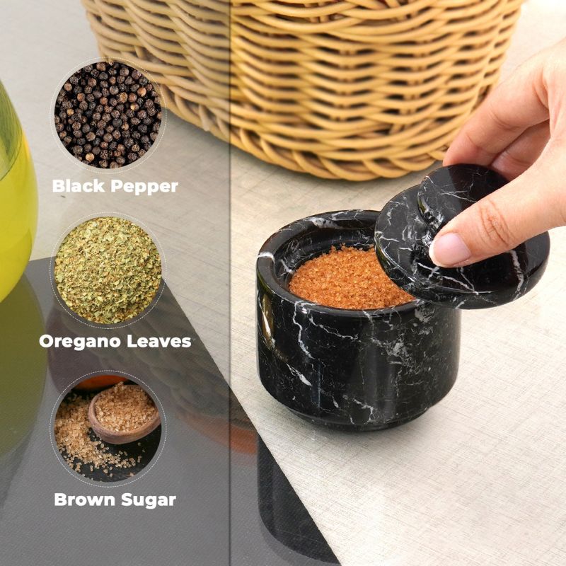 Black marble salt cellar filled with brown sugar, herbs, and spices