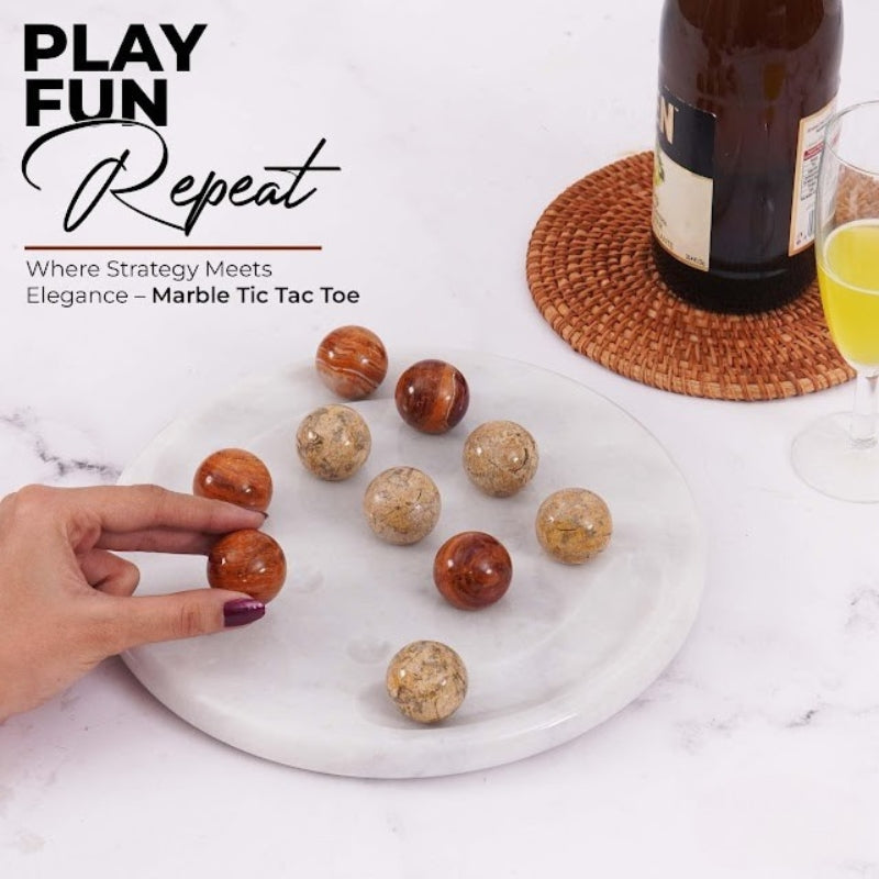 Hand playing with luxury marble tic tac toe game set with brown and beige balls – drinkware in background