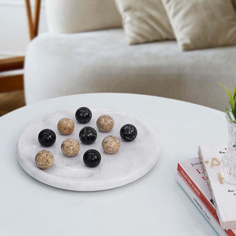 Tic Tac Toe game set on coffee table with black and coral marble balls