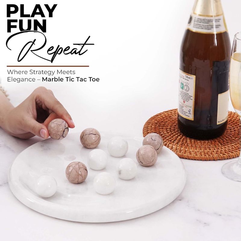 Hand playing Tic Tac Toe with marinara and white marble balls on table