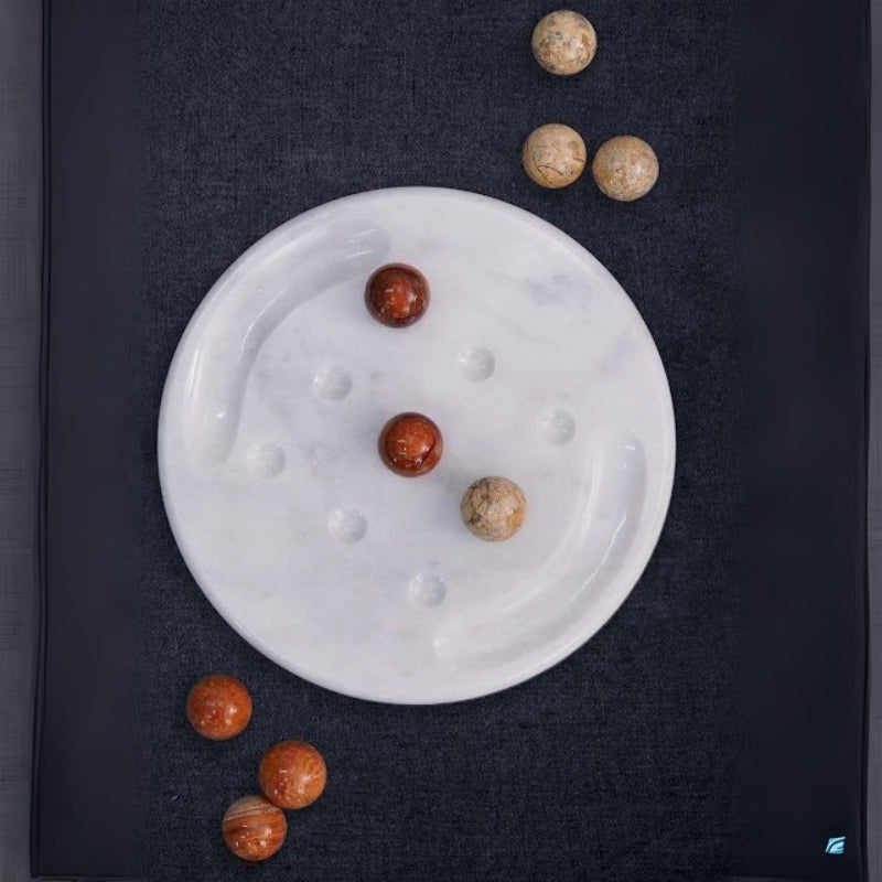 Overhead view of marble tic tac toe board scattered with brown and beige balls – minimalist dark background