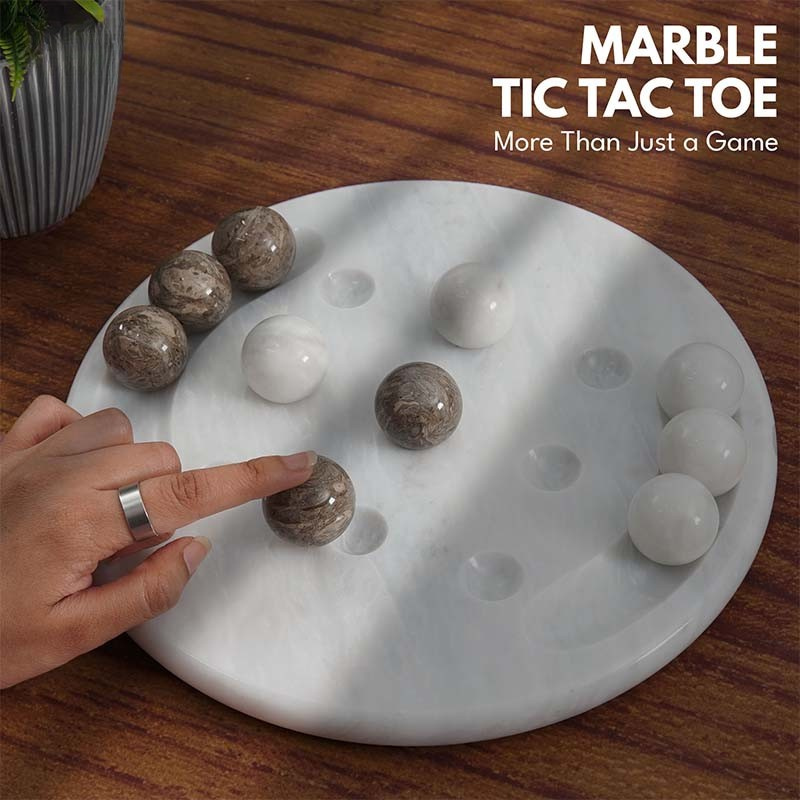 Close-up of oceanic and white marble Tic Tac Toe game set on wooden table, ideal for indoor and outdoor board gaming.