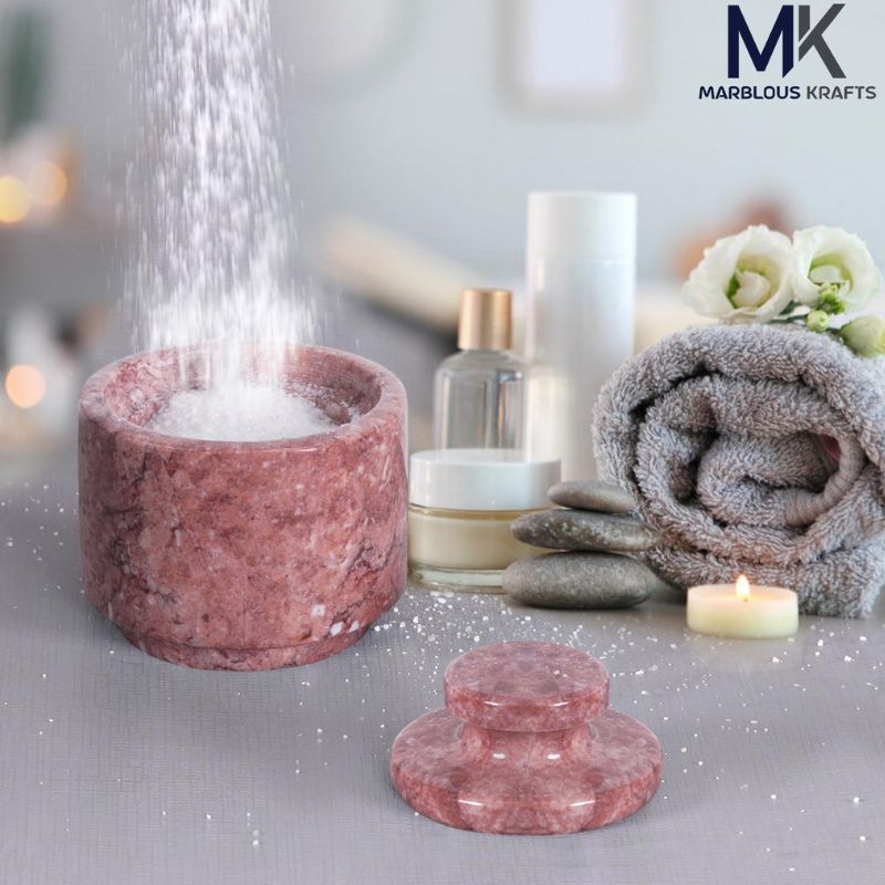Red marble salt cellar in spa setup with bath salt and towel