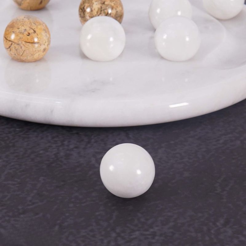 Close-up of white marble ball from Tic Tac Toe game set near board